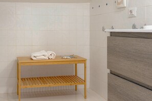 A bathroom with a wooden table, a towel rack, and a sink with a wooden cabinet. - Sea View over Portisco Bay - Spacious 3BR Home - Clima (Porto Rotondo)
