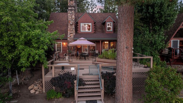 A log cabin with a deck, outdoor seating, and a staircase leading to the entrance. - NEW Lakefront (Location, about the cabin, game room, and more!) (Big Bear Lake)