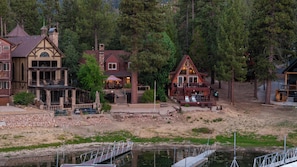A lakeside lodge with a dock, multiple buildings with distinct architectural styles, and a natural forest backdrop. - NEW Lakefront (Location, about the cabin, game room, and more!) (Big Bear Lake)