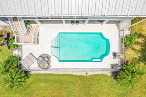A rooftop swimming pool with a deck area, surrounded by grass and palm trees. - 21188 Noddy Tern: 4br Home W/ Pool 4 Bedroom Home (Fort Myers Beach)