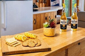 Un taulell de cuina de fusta amb aliments i ampolles de Corona Extra.