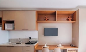 Eine moderne Küche mit integrierten Geräten, einem Flachbildfernseher und einem Essbereich mit Tisch und Stühlen.