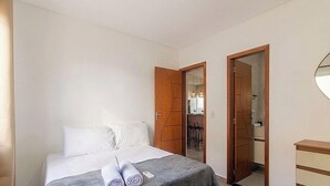 A bedroom with a bed, two doors, a mirror, and a dresser. - Apt. in Condo w/ Pool in Porto Seguro Maa0004 (Porto Seguro)