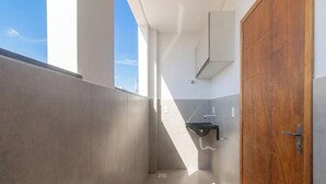 A modern bathroom with a wooden door, a sink, and a window. - Apt. in Condo w/ Pool in Porto Seguro Maa0004 (Porto Seguro)