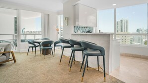 A modern interior with a dining area, kitchen, and large windows offering city views. - Fontainebleau Miami Resort (Miami Beach)