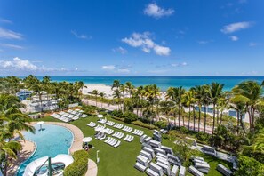 A resort with a swimming pool, lounge chairs, and a view of the beach and ocean. - Fontainebleau Miami Resort (Miami Beach)