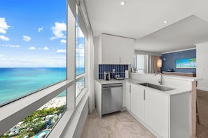 A modern kitchen with a view of the ocean, a built-in dishwasher, and a large window. - Fontainebleau Miami Resort (Miami Beach)