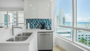 A modern kitchen with a stainless steel sink, a dishwasher, and a coffee maker on the counter. - Fontainebleau Miami Resort (Miami Beach)
