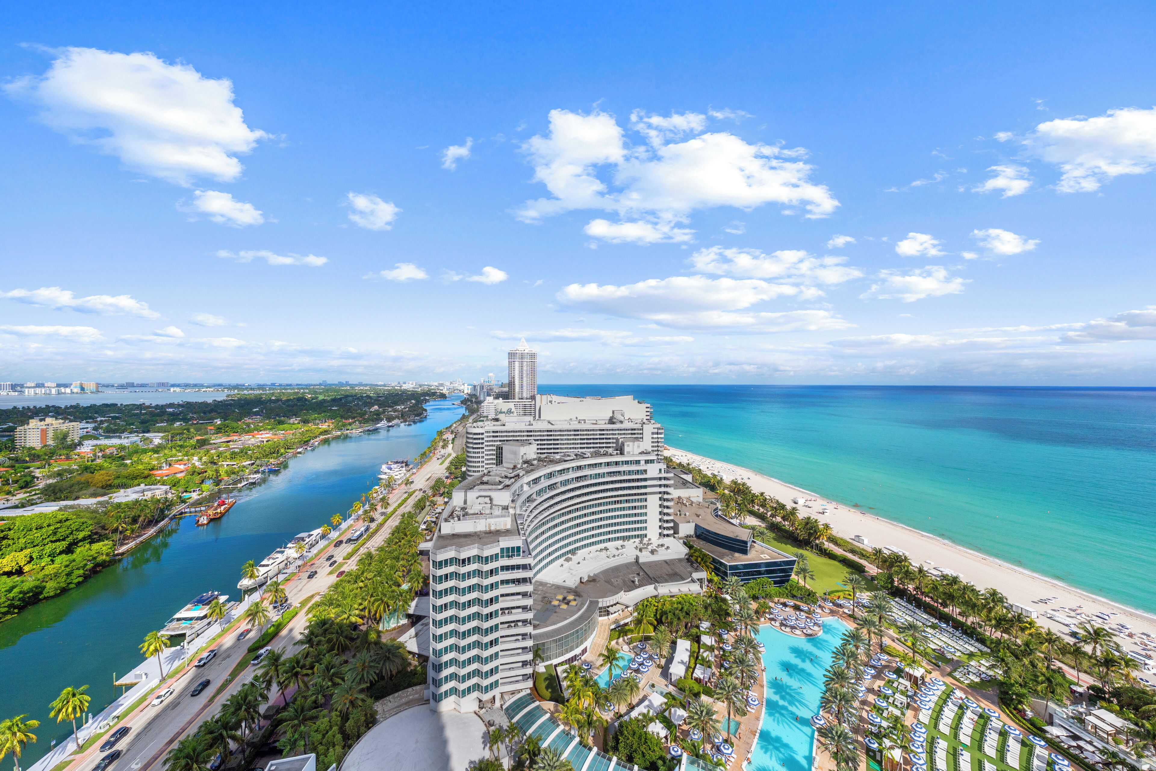 Resort com uma piscina grande, acesso direto à praia e um porto de iates.