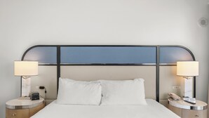 A hotel room with a bed, two bedside tables, a lamp on each table, and a headboard. - Fontainebleau Miami Resort (Miami Beach)