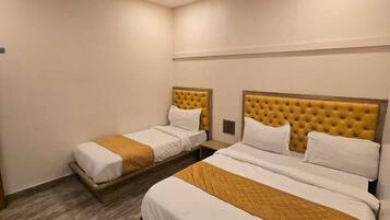 A hotel room with two beds, a ceiling fan, and a wooden floor.