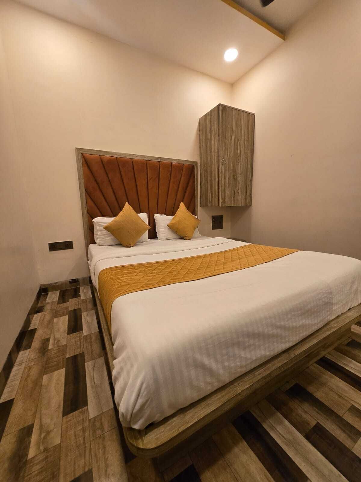 A bedroom with a wooden bed frame, a headboard, and a quilted bedspread.