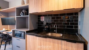 Eine moderne Küche mit schwarzer Arbeitsplatte, Holzschränken und einer Edelstahl-Spüle.