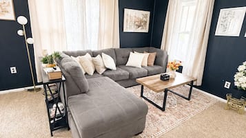 A living room with a sectional sofa, a coffee table, and a floor lamp.