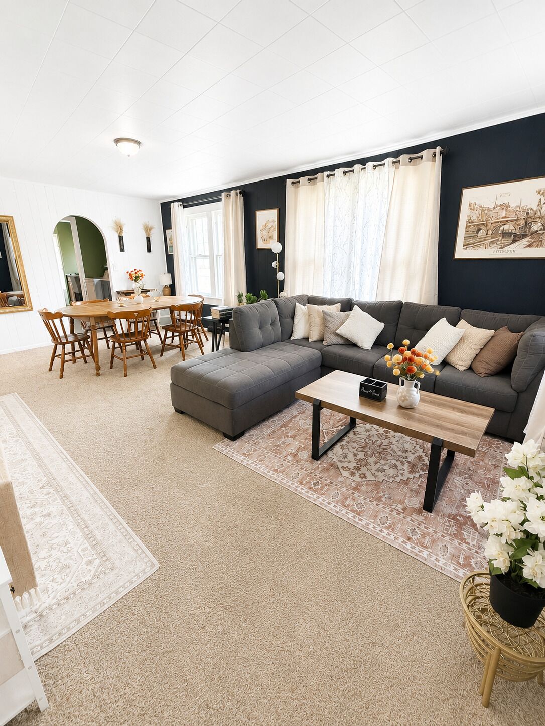 Ein Wohnzimmer mit einer Eckcouch, einem Esstisch mit Stühlen und einem Couchtisch.