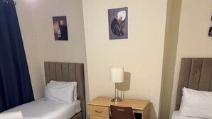 A hotel room with two beds, a desk, a chair, and a rug. - Room-home Away From Home in Salford (Salford)