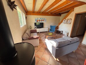 A living room with a sofa, armchair, and a television.