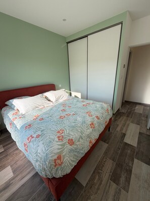 A bedroom with a bed, a wardrobe, and a door.