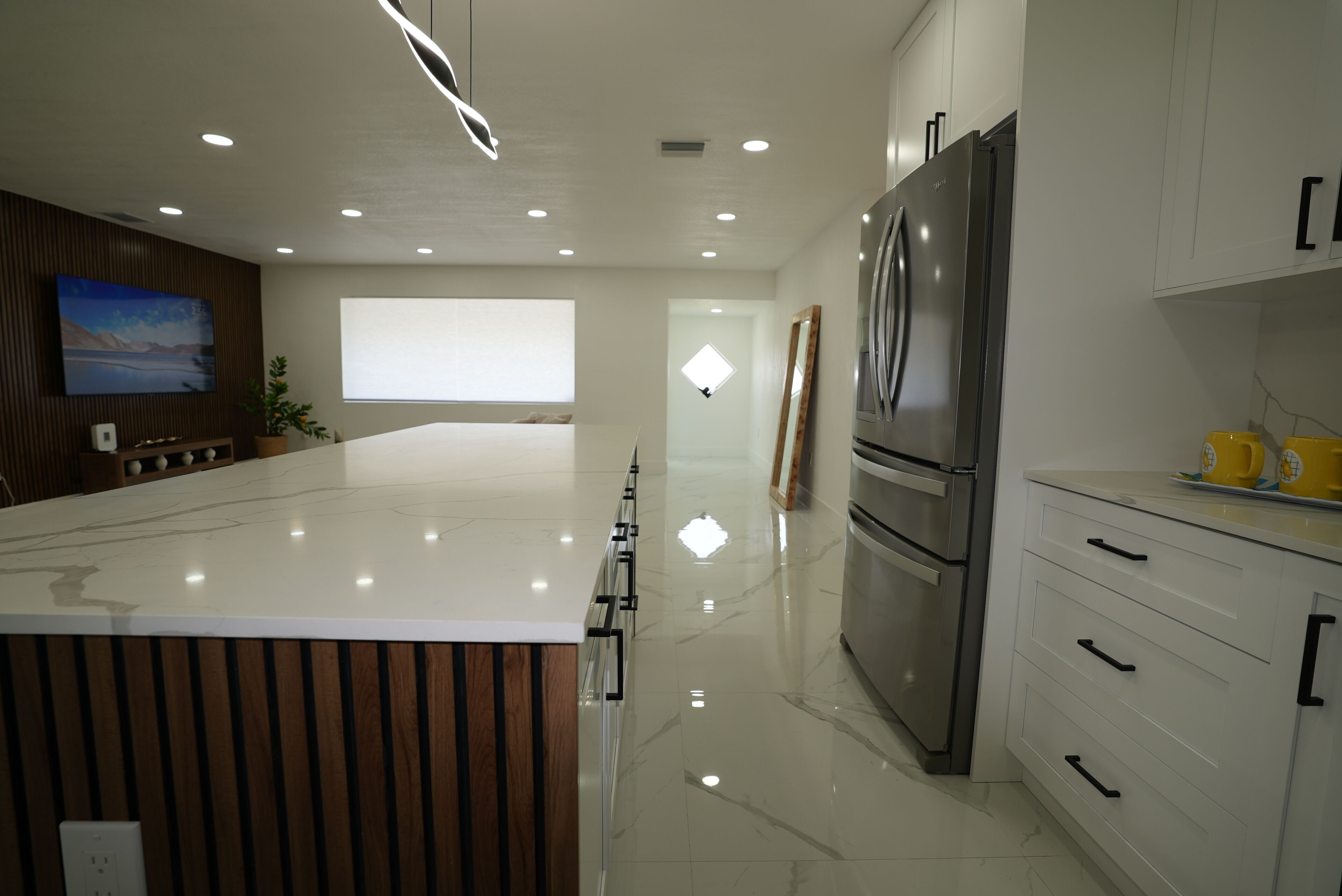 Een moderne keuken met een groot eiland, roestvrijstalen apparatuur en een minimalistisch ontwerp.