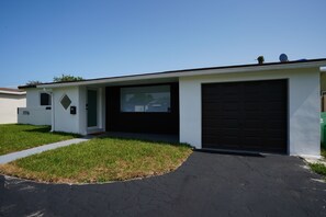 A modern single-story house with a garage, a front door, and a small porch.