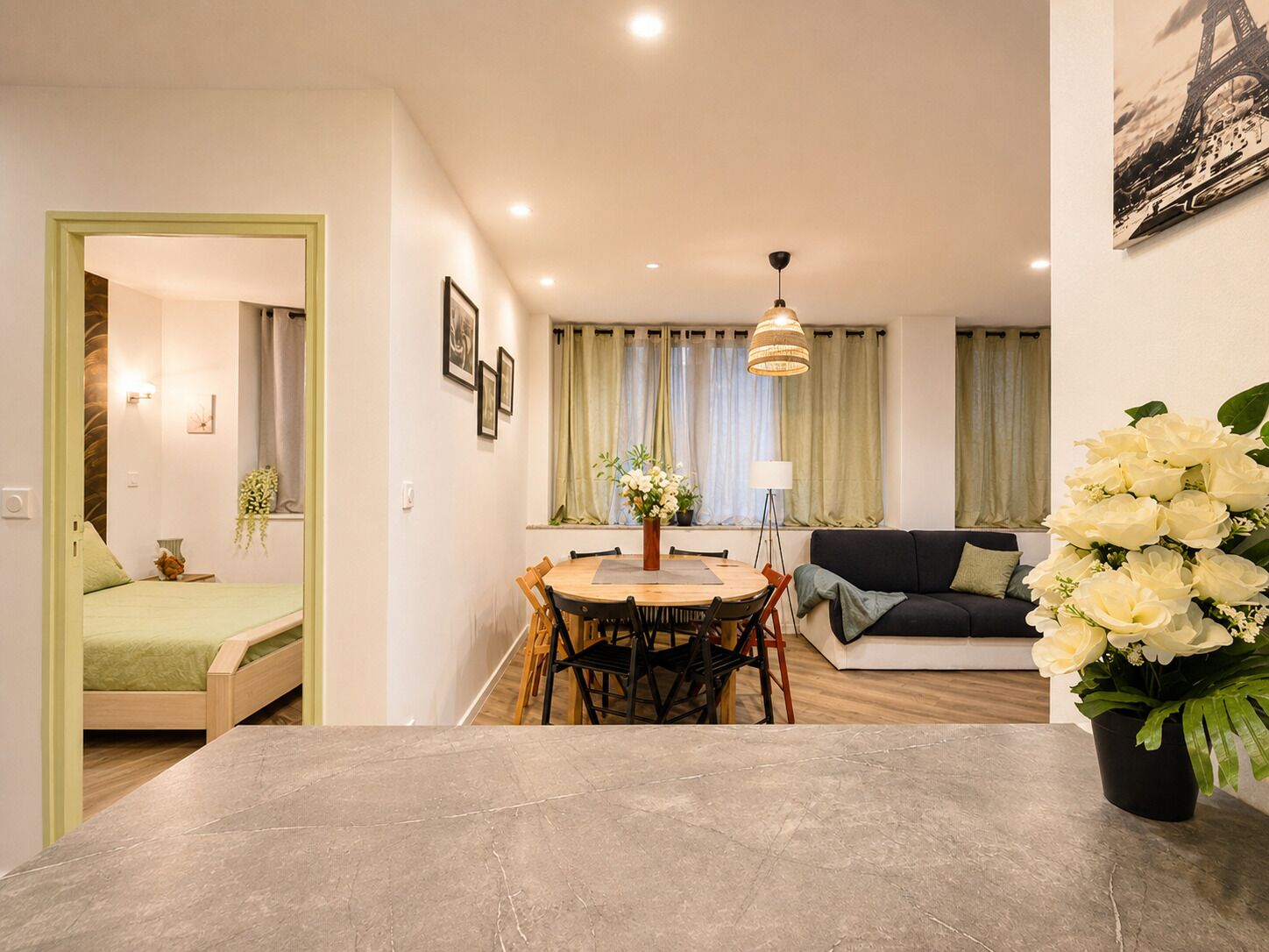 Een moderne woonruimte met een eethoek, een bank en een bed.