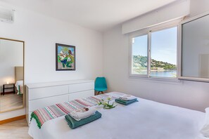 A hotel room with a bed, a chair, a painting, and a window with a view. - FLOTS BLEUS AP4513 By Riviera Holiday Homes (Villefranche-sur-Mer)
