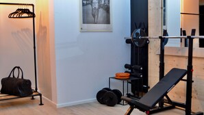 A home gym with a bench press, squat rack, and weight plates.