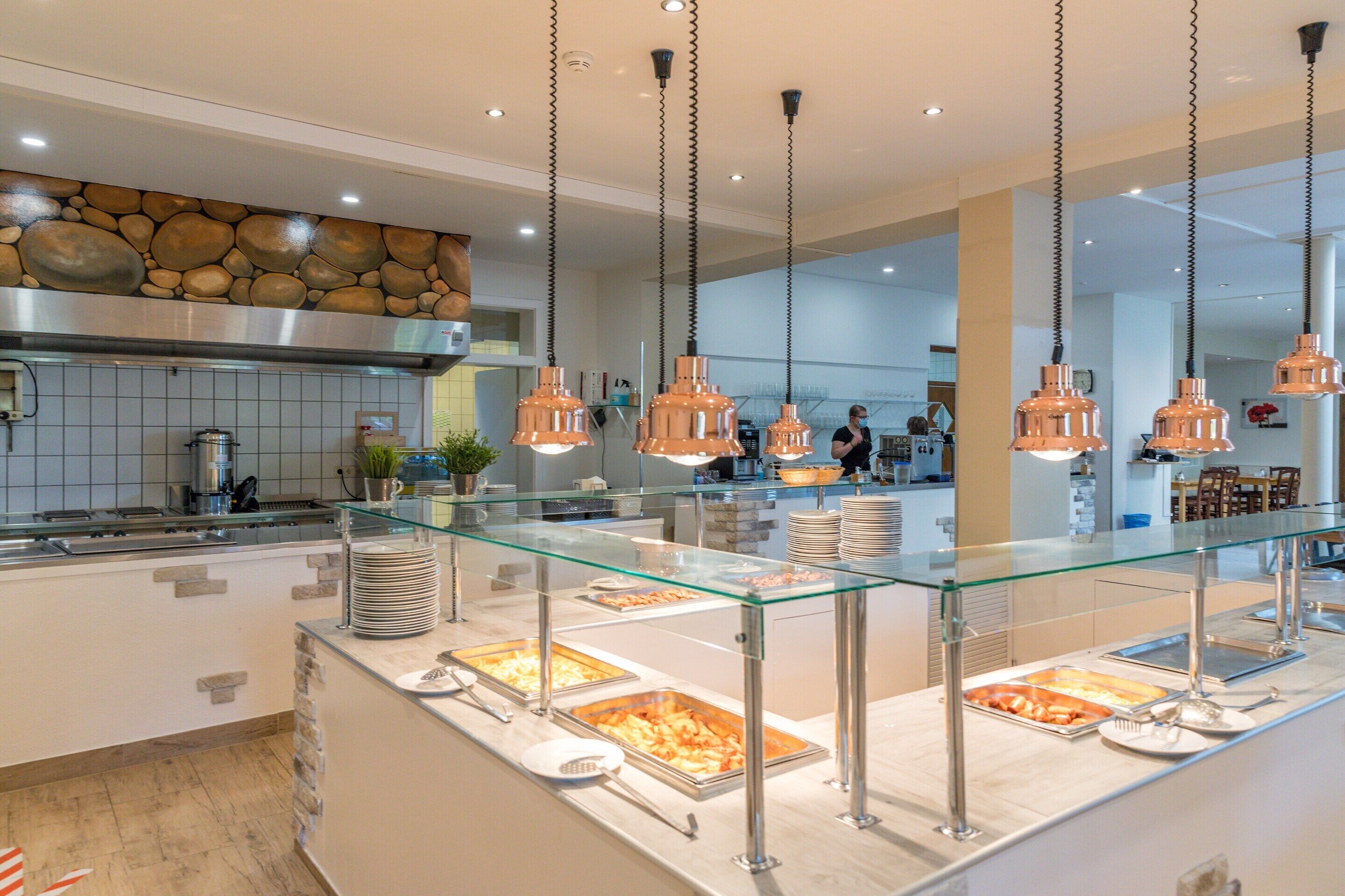 A buffet area with glass display cases and hanging pendant lights.