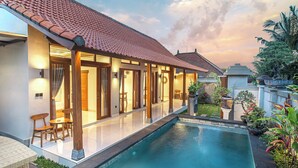 Une maison moderne dotée d’une piscine, de grandes fenêtres et d’un jardin.