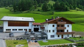 Ein zweistöckiges Gebäude mit einer großen Garage und einem Essbereich mit Außenplätzen.