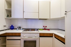 A kitchen with white cabinets, a stove, and a sink. - A cozy studio apartment with a balcony and kitchenette—perfect for two—located within the Campoverde Residence in Vernole, set in a Mediterranean pine forest between San Cataldo and the Le Cesine Nature Reserve. The property is just a short distance  (Vernole)