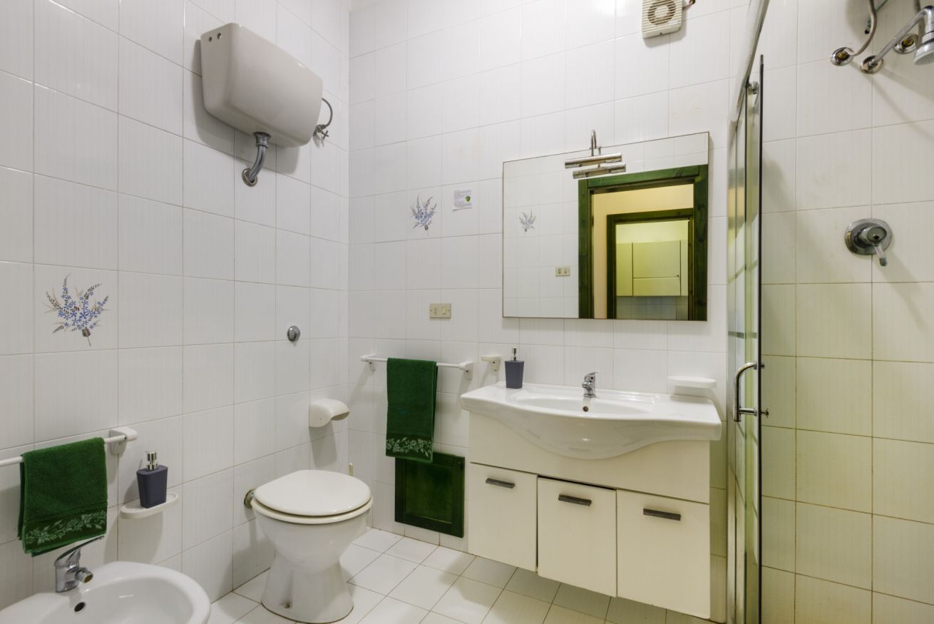 A bathroom with a toilet, sink, and shower.