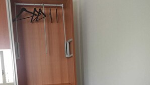 Ein Schrank aus Holz mit Kleiderstange und Schiebetür.