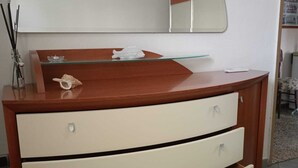 Ein weißer Kommode mit geschwungener Oberseite und mehreren Schubladen.