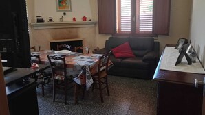 Ein Wohnzimmer mit Kamin, Esstisch und einer Couch.