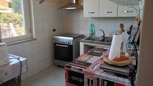 Eine kleine Küche mit Gasherd, Backofen und Spüle.