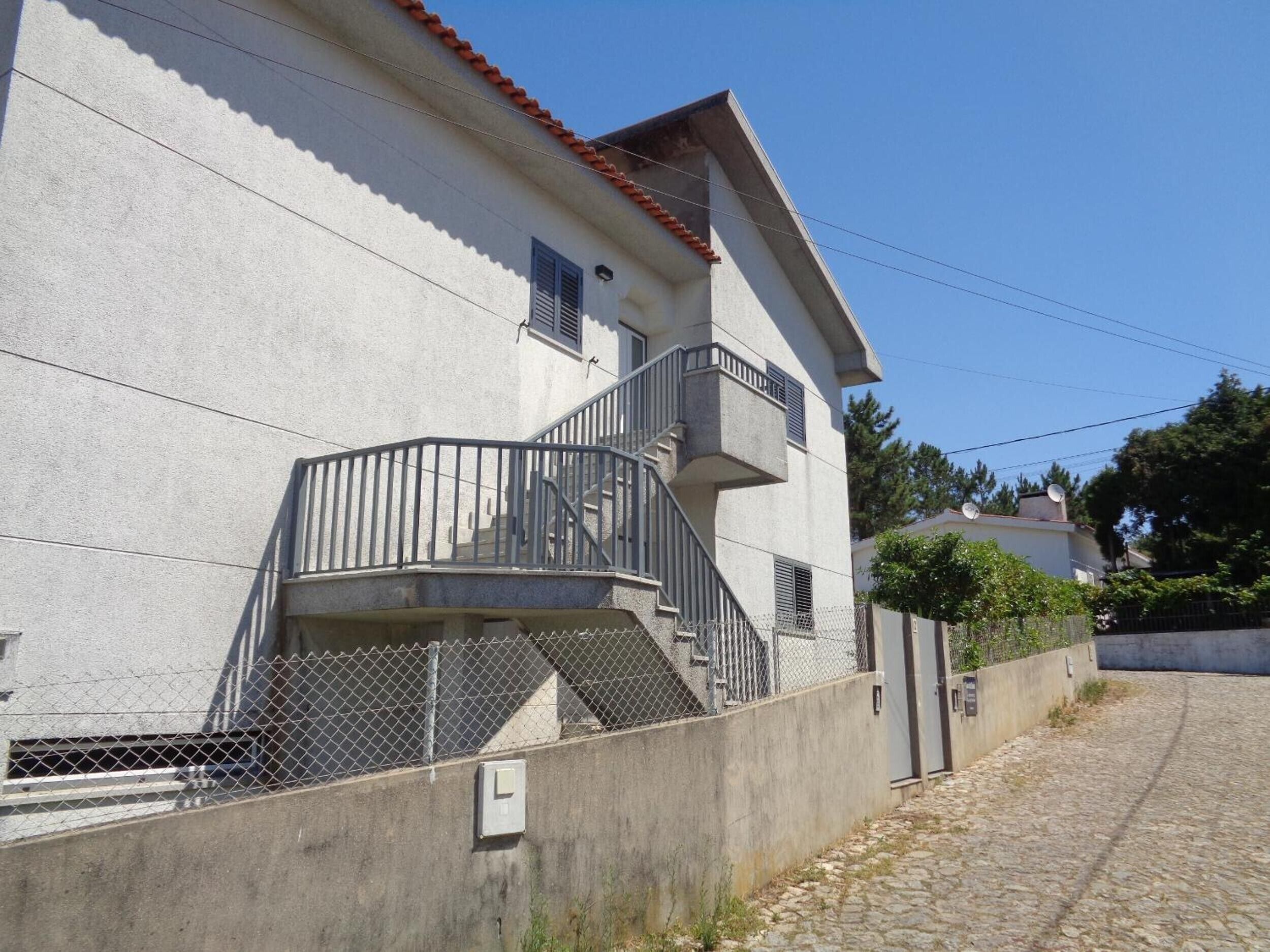 Un edificio de dos pisos con un balcón y una escalera.