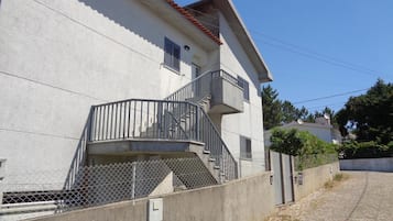 Un edificio de dos pisos con un balcón y una escalera.