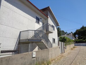 A two-story building with a balcony and a staircase.