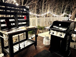 An outdoor barbecue setup with a grill and a table with utensils. - Lake George Getaway w/ Private Pool / Sleeps 12  3BR (Athol)