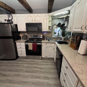 A kitchen with white cabinets, a stainless steel refrigerator, a microwave, and a stove. - Lake George Getaway w/ Private Pool / Sleeps 12  3BR (Athol)
