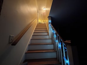 A staircase with wooden steps and a handrail, leading to a landing with a light fixture.