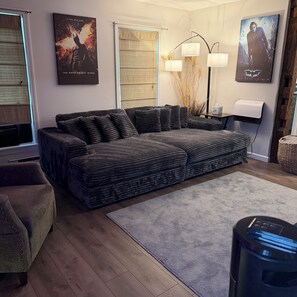 Een moderne woonkamer met een hoekbank, een salontafel en een staande lamp.