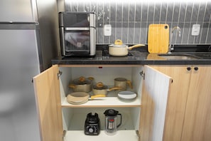 Eine Küche mit Einbauofen, Kaffeemaschine und Mixer auf der Arbeitsfläche.