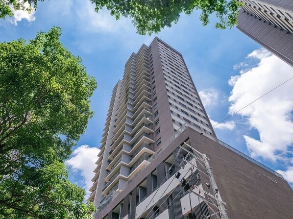 A tall building with a modern design, featuring a series of balconies and a visible exterior elevator system. - Highlights Pinheiros (São Paulo)
