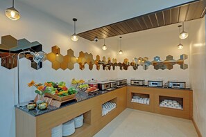 Cocina moderna con un sistema de bufé, que incluye diversas frutas y verduras, además de una selección de electrodomésticos de cocina.