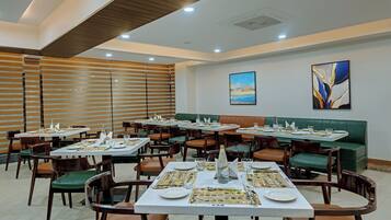 Un restaurante con varias mesas y cabinas, dispuesto en un espacio amplio.