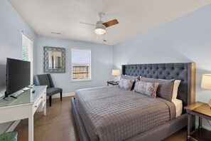 A bedroom with a bed, a desk, a chair, a television, a ceiling fan, and a window with blinds. - New listing! 4-BR Moab Retreat | Pool | Hot tub | Fenced yard with BBQ (Moab)