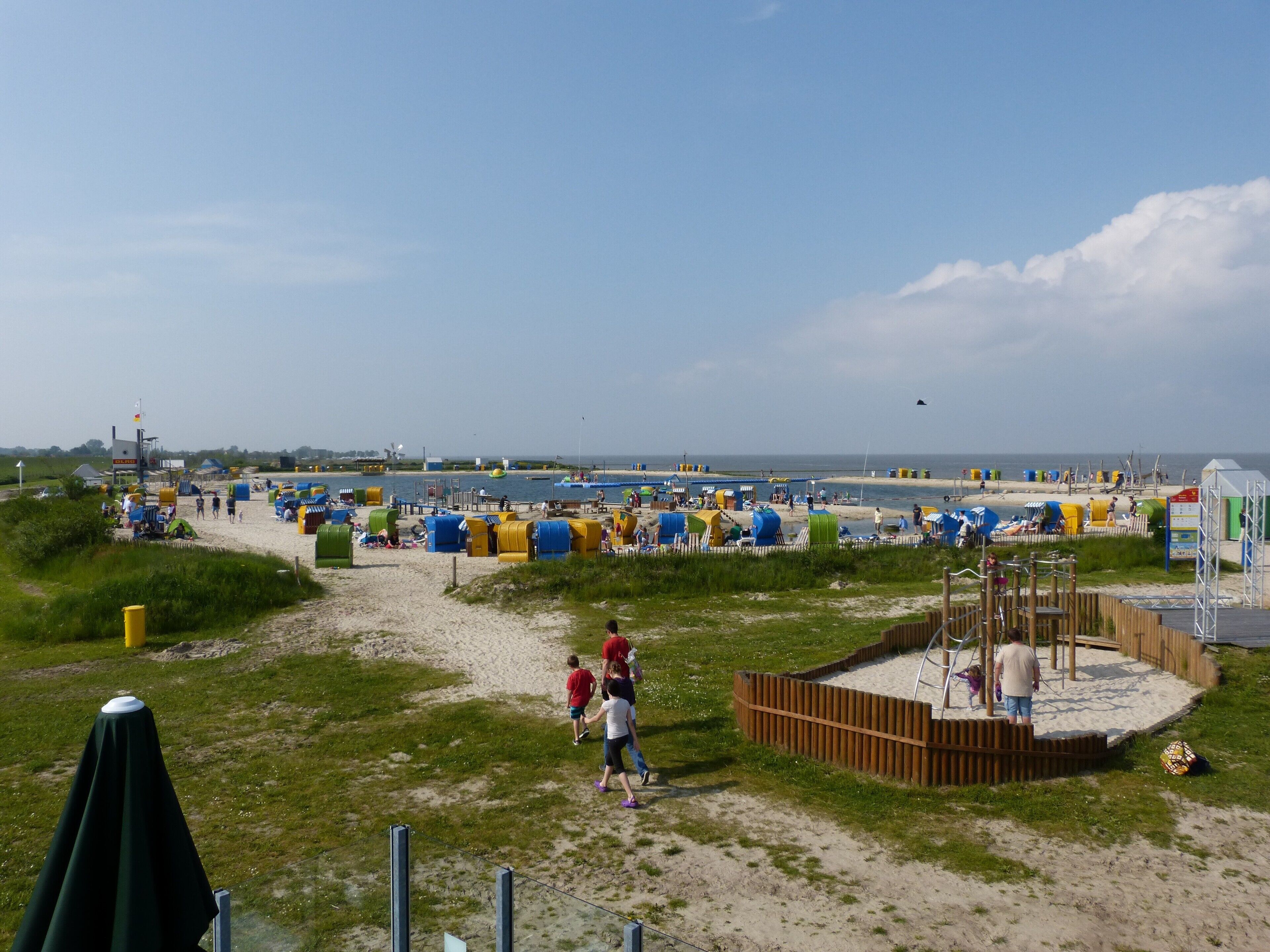 Ein Strand mit Zelten und einem Spielplatz.