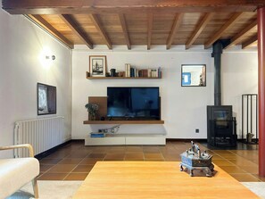 Una sala de estar con televisor, estanterías, chimenea y sofá.